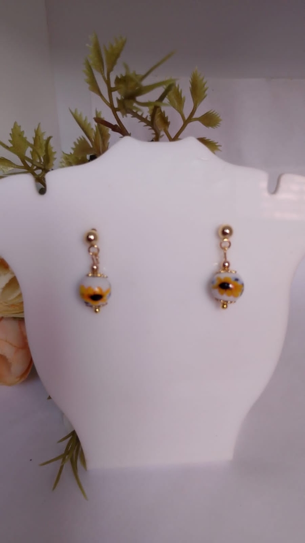 Brincos banhados em ouro, pingente de muranos com desenho de girassol.